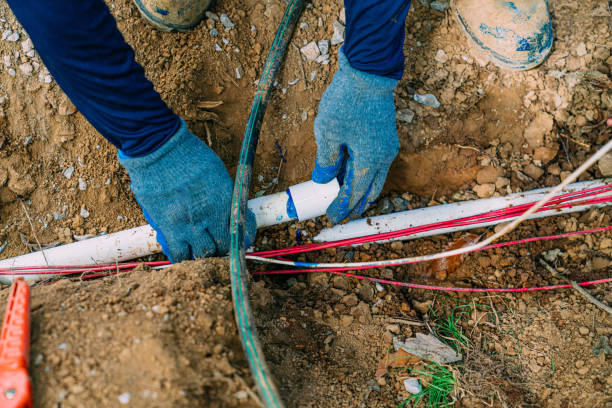 Plumber installing underground water line and plumbing pipes.